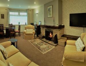 斯卡伯勒Woodpeckers Cottage的客厅设有壁炉和电视。