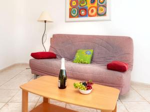兰卡Apartment Palmiers I-1 by Interhome的客厅配有沙发和一张桌子及一瓶葡萄酒