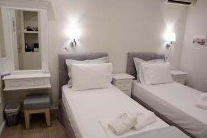 斯派赛斯LEVANTA HOTEL SPETSES的小型客房的两张床,配有镜子