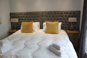 柯克沃尔Apt 1, Frasers Close, Kirkwall的卧室配有一张带黄色枕头的大型白色床。