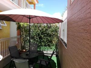 锡拉奥奥特罗萨酒店的庭院配有桌椅和遮阳伞。