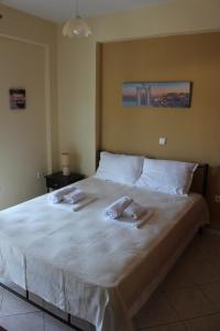 奥弗里安Paralia Ofriniou GR sunrise apartments 3的一张白色的大床,带两条毛巾