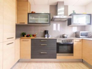 安波拉Holiday Home Cap Roig by Interhome的厨房配有不锈钢用具和木柜