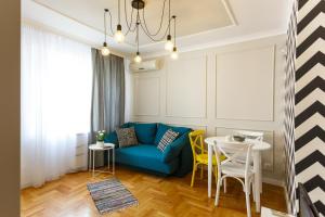 索非亚CityResidence Aparthotel的客厅配有蓝色的沙发和黄色的椅子