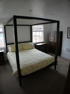 林肯磨房路22度假屋酒店的一间卧室,卧室内配有一张天蓬床