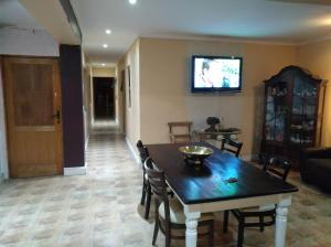 MatroosfonteinLiziwe's Guest House的客厅配有桌子和墙上的电视