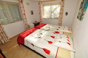 拉戈斯VIVENDA JOHANNA的一间卧室,床上有红色的鲜花
