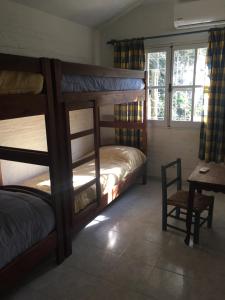马尔多纳多Casa Azul的一间卧室配有双层床、一张桌子和一张书桌