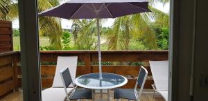 勒穆莱Jardin D'eden的阳台配有桌椅和遮阳伞