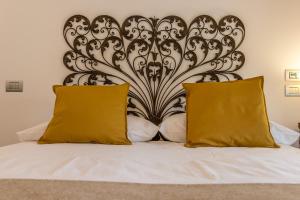 马塞拉-迪帕多瓦B&B Botanical Boutique的一张带两个黄色枕头和床头板的床