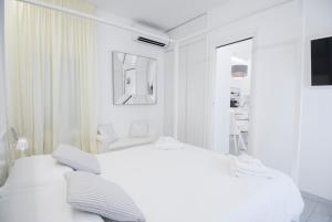 马尔米堡White Apartment的白色的卧室配有白色的床和镜子