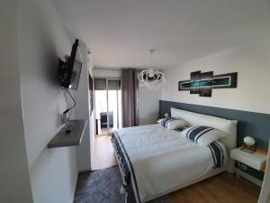 马赛Appartement T2 Prado Chanot Plage Marseille的一间卧室配有一张床,墙上配有电视