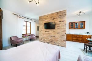 卢布林Apartamenty Magia的卧室设有砖墙、一张床和电视
