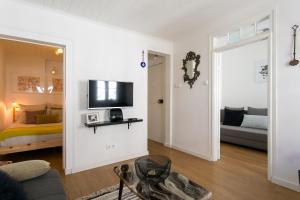 里斯本Green Street - lovely historic center apartment的客厅设有床铺和墙上的电视