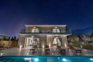 特拉佩扎奇Kefalonia Stone Villas - Villa Petros Kefalonica的夜间带游泳池的别墅