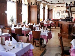 霍亨斯泰因-埃尔恩斯塔尔Hotel DREI SCHWANEN - Ristorante Due Fratelli的餐厅配有桌椅和白色的桌布