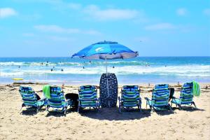 圣地亚哥Luv Oceanside-1 House to Beach的海滩上的一组椅子和一把遮阳伞