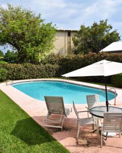 科纳Holualoa Garden 303的游泳池旁配有桌椅和遮阳伞
