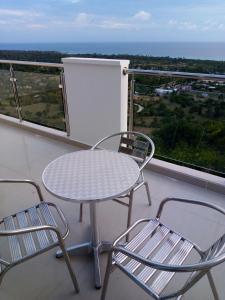 Port-SalutResidences Sommet Port Salut的阳台上配有一张白色的桌子和两把椅子