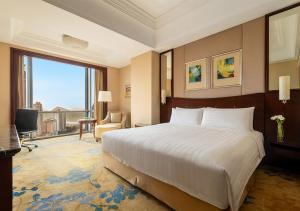 苏州苏州香格里拉的酒店客房设有一张床和一个大窗户