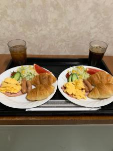 一宫市Osyare Kizoku Ichinomiya (Adult Only)的托盘上的两盘食物,两杯饮料