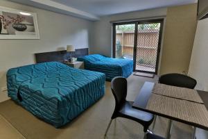 悉尼史卓菲行政住宿酒店的卧室配有一张床和一张桌子及椅子