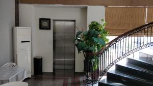 雅加达55号酒店的电梯旁的楼梯,有盆栽植物