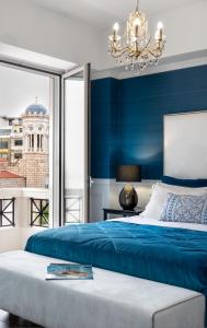 雅典Evripidou Suites的一间蓝色卧室,配有一张床和一个吊灯
