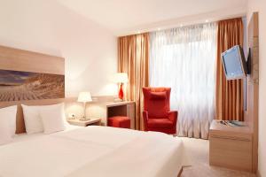 海德柏林诺迪卡酒店的配有一张床和一把椅子的酒店客房