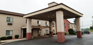 巴达维亚FairBridge Inn & Suites Batavia-Darien Amusement Park的酒店停车场,有一座大建筑