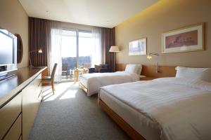华城市蜿蜒山岭酒店的酒店客房设有两张床和电视。