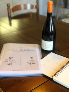 PouilléAu Coeur des Vignes的一瓶葡萄酒和一张桌子上的笔记本