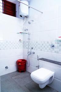 迈索尔UNNATHI SUITES的一间带卫生间和红色桶的浴室