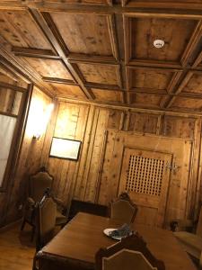 San BernardoHotel Albrici的一间带桌子和木制天花板的用餐室