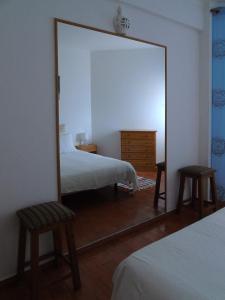 卢斯Cantinho Das Estrelas, Luz Lagos的卧室内的镜子,配有一张床和两把椅子