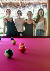 阿鲁甘湾Riva del Sole Guest House的一组三名妇女站在一张台球桌旁
