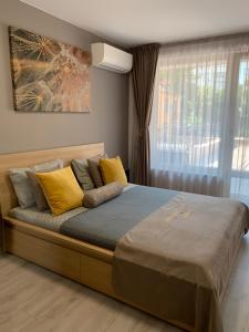 普罗夫迪夫Kapana Luxury City Center Apartments with Garage的卧室内的一张带黄色枕头的大床