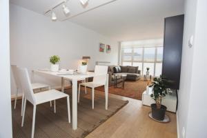 奥利奥Orio playa lucirá的用餐室以及带白色桌椅的起居室。