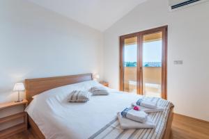 科里米诺奥莉亚岛公寓的白色卧室配有带2条毛巾的床