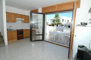 莱乌卡Residence Trande的厨房设有滑动玻璃门,可通往庭院。