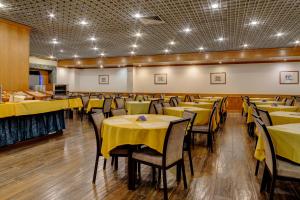 里斯本贝赫那VIP酒店的用餐室配有黄色的桌椅