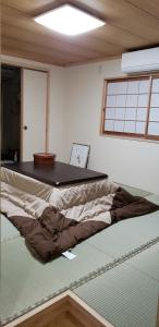 长崎GardenRoom bnb Yumyum的一张位于房间的床,上面有桌子