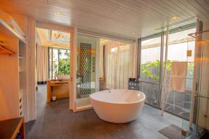 纳泰海滩Baba Beach Club Natai Luxury Pool Villa Hotel by Sri panwa - SHA Plus的带浴缸和大窗户的大浴室