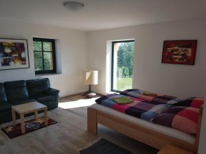 恰斯拉夫Penzion/Motorest Na Písku的一间卧室配有一张床、一张沙发和一个窗口