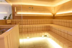 莱赫阿尔贝格Hubertus, 3 Sterne Superior的设有带木墙和天花板及灯光的桑拿浴室