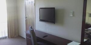 韦尔科姆Welkom Inn的一间酒店客房内的墙上设有一台平面电视