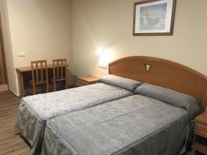 乌马内斯-德马德里拉乌尼翁酒店的卧室配有1张床、1张桌子和1把椅子