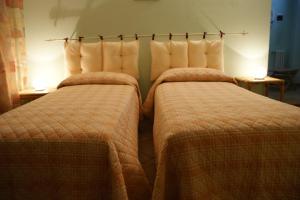 VinovoB&B La Braida的两张睡床彼此相邻,位于一个房间里