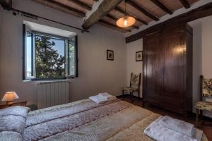 埃尔萨谷口村Agriturismo Tenuta Di Mensanello的一间卧室设有一张大床和一个窗户。