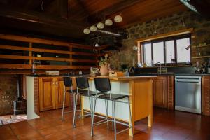 塞尔丘克Villa Demeter的厨房配有木制橱柜和带酒吧凳的台面。